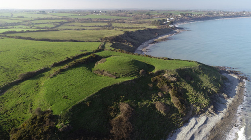 Aerial view of green cliff top with raised round area