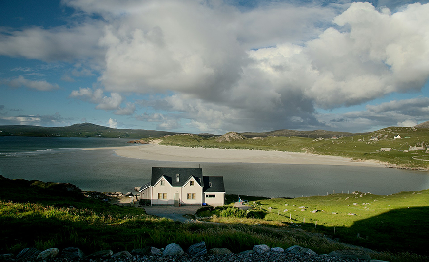 Coastal scene with white cottage in foreground